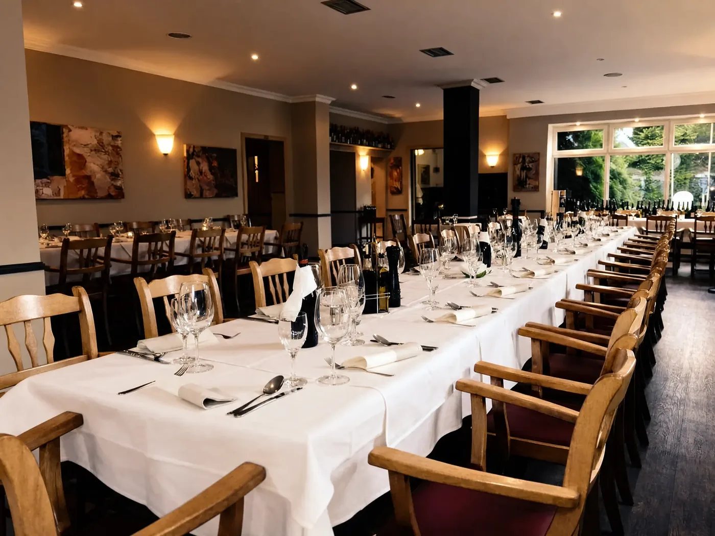 Innenraum des Ristorante Alsterschleuse: festlich gedeckte Tafeln mit Kerzen, Holzstühlen und Weinschränken